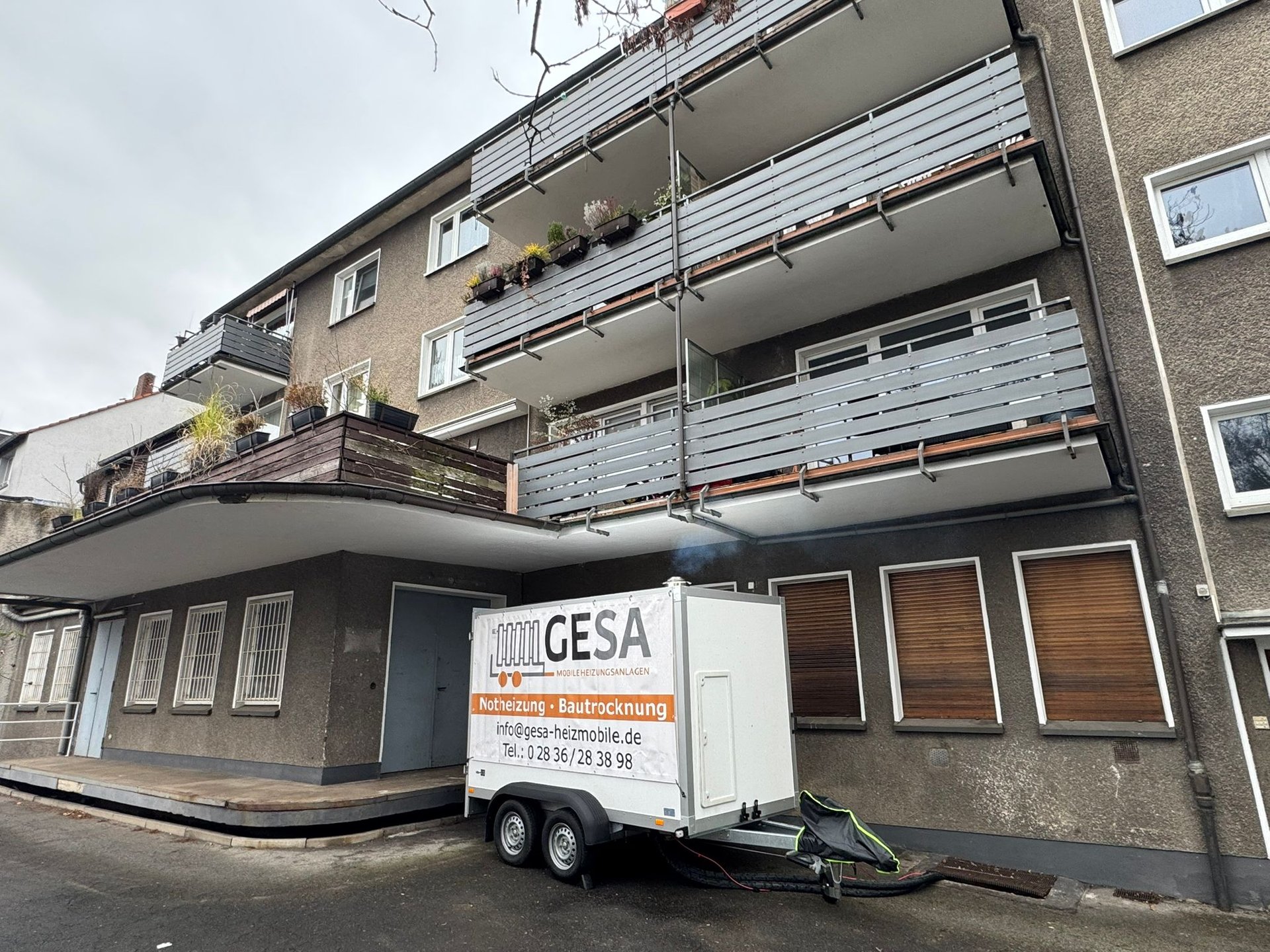 GESA moving truck parked in front of a multi-story residential apartment building